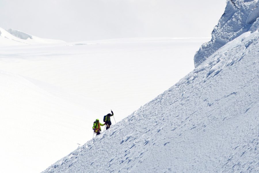 Two people climbing a mountain